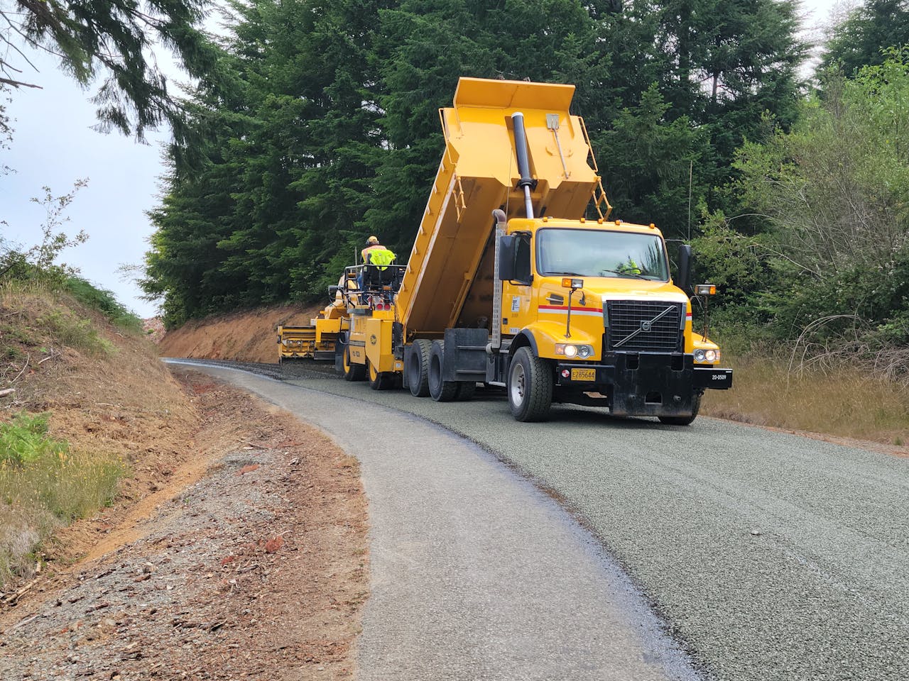 gallery-01 A yellow dump truck paving a forest road in Langlois, Oregon, USA.