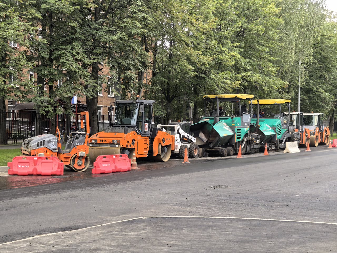 services-03 Heavy machinery for roadwork lined up on an urban street during daytime construction.
